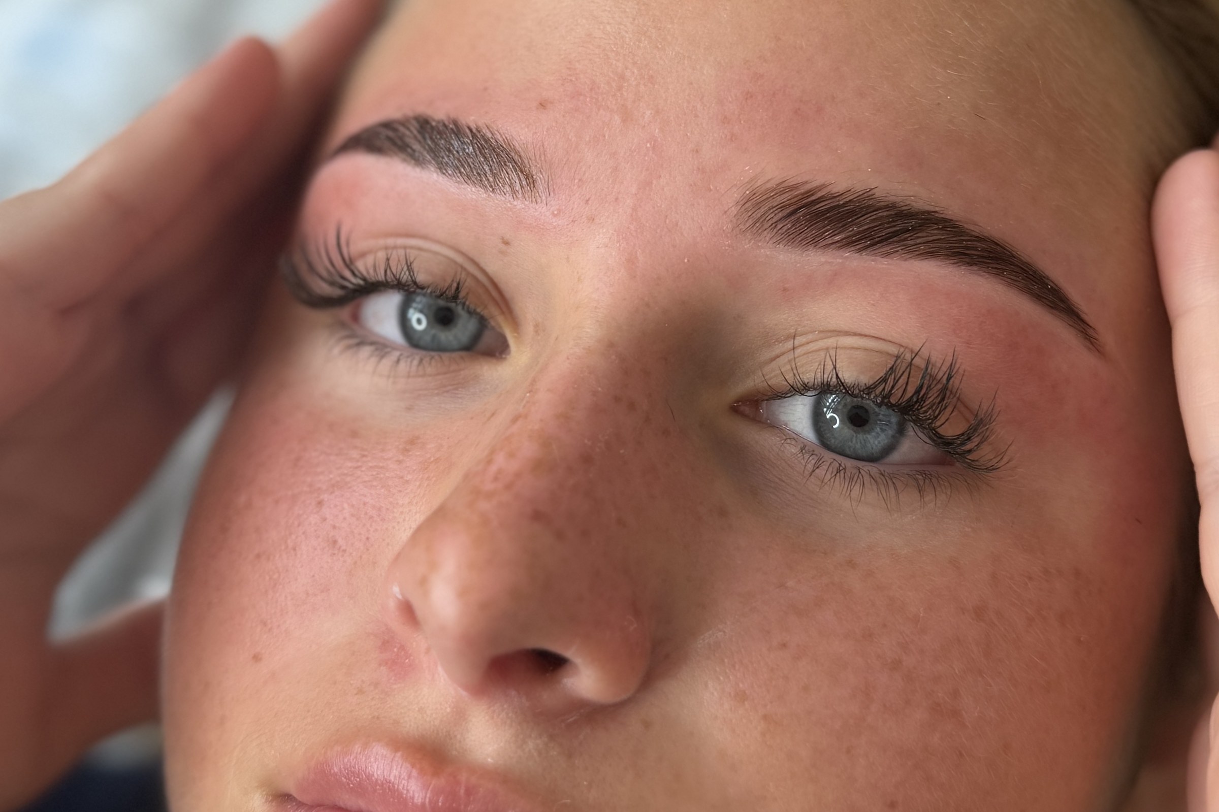 A client at La Muse Beauty Bar with freshly laminated and tinted brows